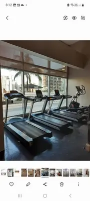 a row of empty treadmills in a gym at Quaint Aparthotel T22306 in Manila
