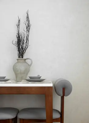 a table with a vase on top of it with plates and a vase at Sarannya Home BGC in Manila
