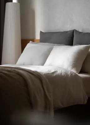 a bed with white sheets and pillows in a bedroom at Sarannya Home BGC in Manila