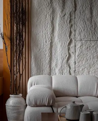 a living room with a white couch and a wall at Sarannya Home BGC in Manila