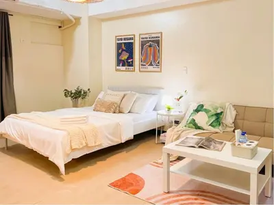 a bedroom with a white bed and a table at Stylish 1BR Venice Mall, Pool, Fast WiFi #vlrtc17e in Manila
