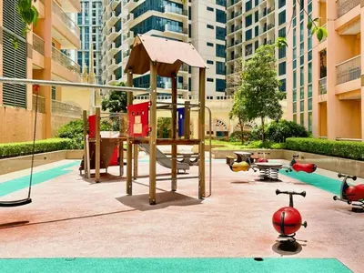 a playground with a slide and a swing set at Stylish 1BR Venice Mall, Pool, Fast WiFi #vlrtc17e in Manila