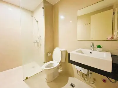 a bathroom with a toilet and a sink at Stylish 1BR Venice Mall, Pool, Fast WiFi #vlrtc17e in Manila