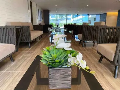 a lobby with a vase of flowers on a table at Air Residences - Panoramic City View near Airport - 4734 in Manila