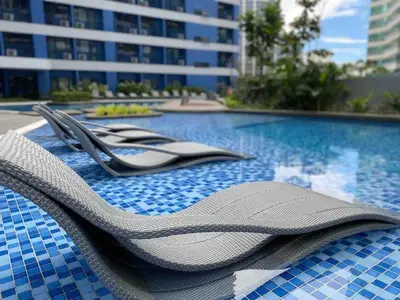 a pair of flip flops sitting on top of a swimming pool at Air Residences - Panoramic City View near Airport - 4734 in Manila