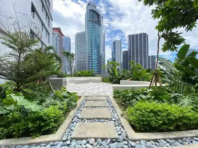 a garden in a city with tall buildings at Air Residences - Panoramic City View near Airport - 4734 in Manila