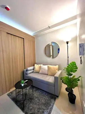 a living room with a couch and a table at Jen staycation in Manila