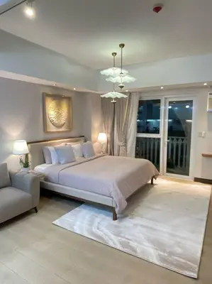 a bedroom with a large bed and a couch at Minimalist and cozy place with balcony in Manila
