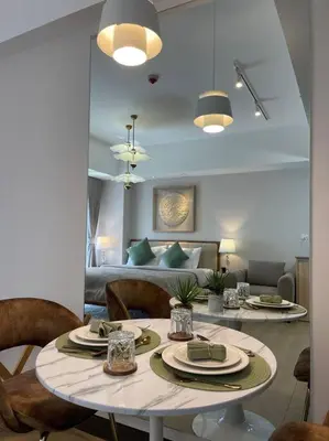 a living room with a table and chairs and a couch at Minimalist and cozy place with balcony in Manila