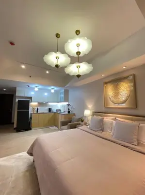 a large bedroom with a large white bed and lights at Minimalist and cozy place with balcony in Manila
