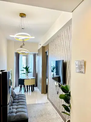 a living room with a couch and a table at Cosy Deluxe Flat with Balcony near MOA in Manila