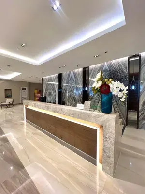 a lobby with a reception counter with a vase of flowers at Cosy Deluxe Flat with Balcony near MOA in Manila