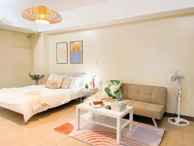 a living room with a bed and a couch at Elegant Condo at Venice Grand Canal BGC #vlrtc27e in Manila