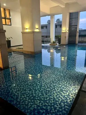 a swimming pool with a tile floor in a building at Greenbelt Hamilton Tower 1 Legazpi Makati City - by ES Elite Suites in Manila