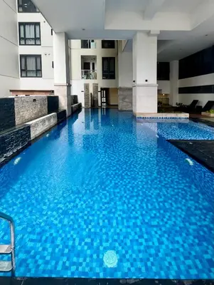a large pool with blue water in a building at Greenbelt Hamilton Tower 1 Legazpi Makati City - by ES Elite Suites in Manila