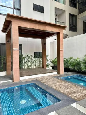 a building with a swimming pool in front of a building at Greenbelt Hamilton Tower 1 Legazpi Makati City - by ES Elite Suites in Manila