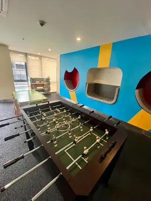 a ping pong table in a room with avertisement at Greenbelt Hamilton Tower 1 Legazpi Makati City - by ES Elite Suites in Manila