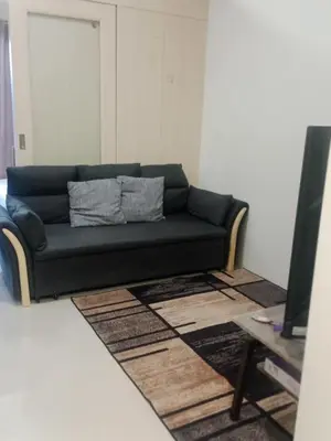 a black couch in a living room with a television at Jazz stacation in Manila