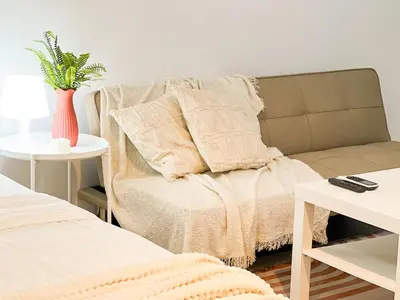 a bedroom with a couch and a table with a vase at BGC Luxury, Venice Grand Canal Mall #vlrtc27c in Manila