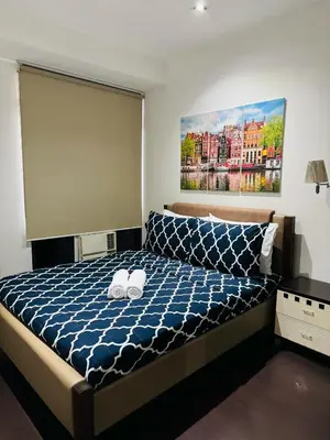 a bedroom with a bed with two towels on it at Makati City Studio with Balcony Near Bgc And Airport in Manila