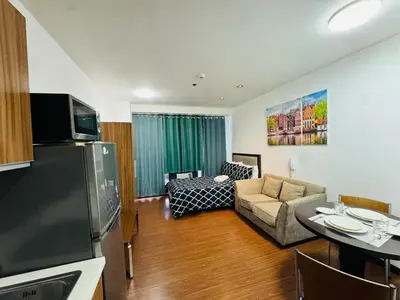 a living room with a couch and a table at Makati City Studio with Balcony Near Bgc And Airport in Manila