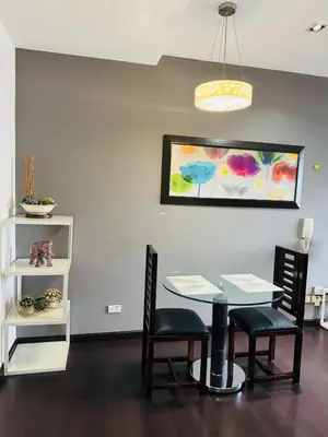 a dining room with a table and chairs and a painting at Makati City Studio with Balcony Near Bgc And Airport in Manila
