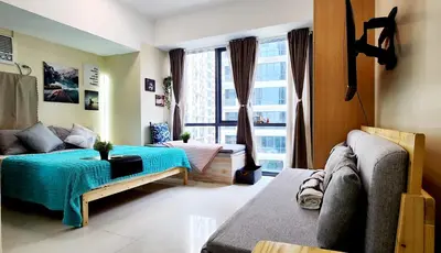 a living room with a couch and a large window at xxxCozy Family Retreat 8 mins walk from Venice Grand Canal Mall BGC fits 5 pax in Manila