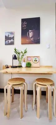 a wooden table with two stools in front of a desk at xxxCozy Family Retreat 8 mins walk from Venice Grand Canal Mall BGC fits 5 pax in Manila
