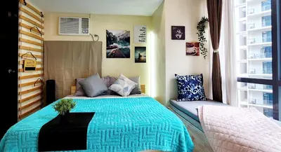 a bedroom with a bed with a blue blanket at xxxCozy Family Retreat 8 mins walk from Venice Grand Canal Mall BGC fits 5 pax in Manila