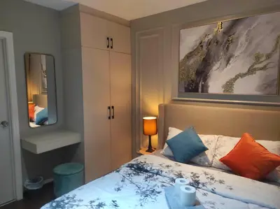 a bedroom with a bed with colorful pillows at Newly Interiored 1 Bedroom with Balcony, City, Manila Bay and Sunset View with Netflix, Free Access to Infinity Pool, Gym, Sauna in Manila