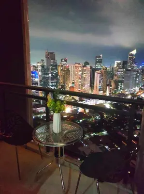 a table with a vase of flowers on top of a city skyline at Newly Interiored 1 Bedroom with Balcony, City, Manila Bay and Sunset View with Netflix, Free Access to Infinity Pool, Gym, Sauna in Manila