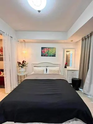 a bedroom with a large bed with a black blanket at A2Z Staycation at Azure Urban Residences in Manila