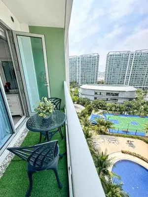 a balcony with a table and chairs and a pool at A2Z Staycation at Azure Urban Residences in Manila