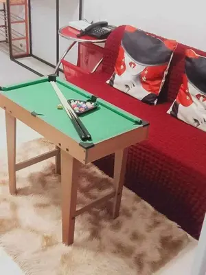 a ping pong table in front of a couch at A2Z Staycation at Azure Urban Residences in Manila