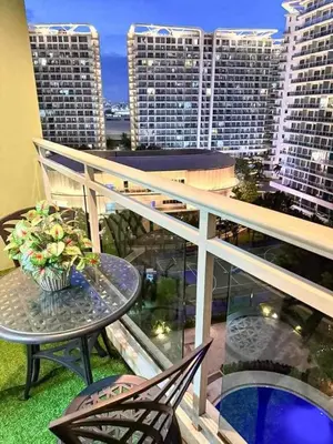 a balcony with a table and chairs and some buildings at A2Z Staycation at Azure Urban Residences in Manila