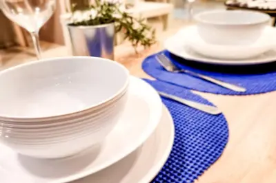 a table with white plates and a blue napkin at Homey 2br Apt 5 in Makati City in Manila