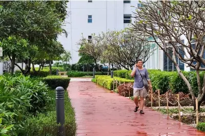 a woman walking down a path in a park at Homey 2br Apt 5 in Makati City in Manila