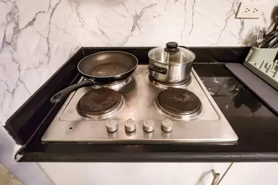 a stove top with two pots and pans on it at Homey 2br Apt 5 in Makati City in Manila