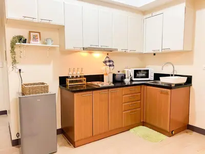 a kitchen with white cabinets and a sink at Stylish Condo, Venice BGC, Pool, WiFi #vlrtc29e in Manila