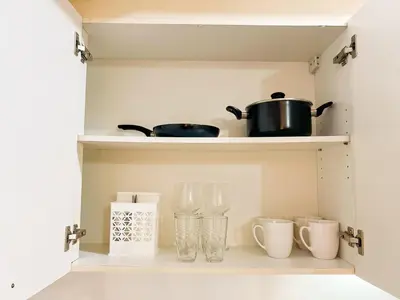 a kitchen shelf with pots and vases on it at Stylish Condo, Venice BGC, Pool, WiFi #vlrtc29e in Manila