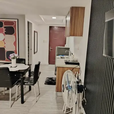 a living room with a table and a fan at ADB Avenue Tower Staycation in Manila
