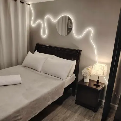 a bedroom with a bed with a mirror on the wall at ADB Avenue Tower Staycation in Manila