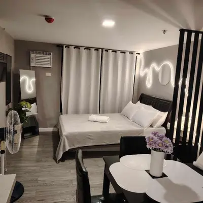 a room with a bed and a table with chairs at ADB Avenue Tower Staycation in Manila