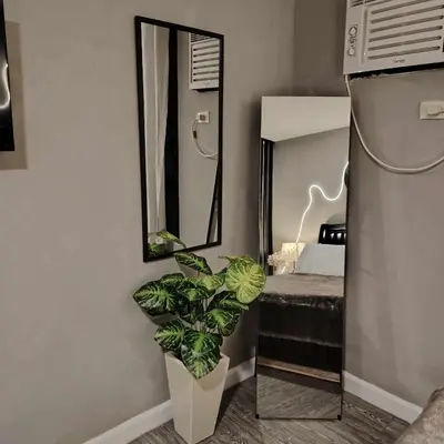a bathroom with a mirror and a plant at ADB Avenue Tower Staycation in Manila