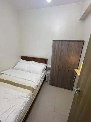 a bedroom with a bed and a wooden door at Modern & Cozy Space near NAIA Terminal 1 in Manila