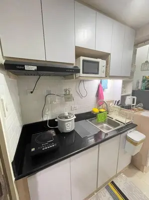 a small kitchen with a stove and a microwave at Modern & Cozy Space near NAIA Terminal 1 in Manila