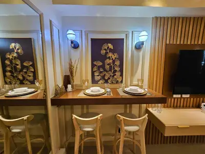 a dining room with a table and chairs and a television at Lourdes' Place, Shore 2-Tower 1, 2 Beds, Pasay near Mall of Asia in Manila