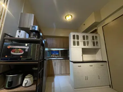 a small kitchen with white cabinets and a microwave at Mirea Residences Pasig- Two Bedroom Condo Unit with Balcony 70sqm in Manila