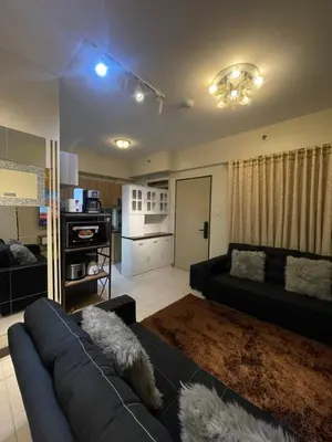 a living room with a couch and a kitchen at Mirea Residences Pasig- Two Bedroom Condo Unit with Balcony 70sqm in Manila