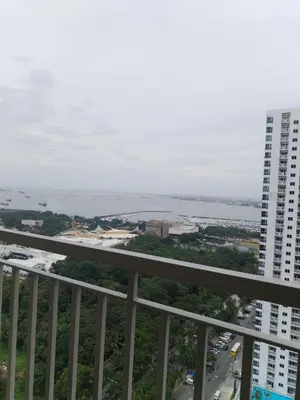 a view of the ocean from a balcony of a building at Coast Residence Sea View Balcony Netflix WiFi Near MOA 3146 in Manila